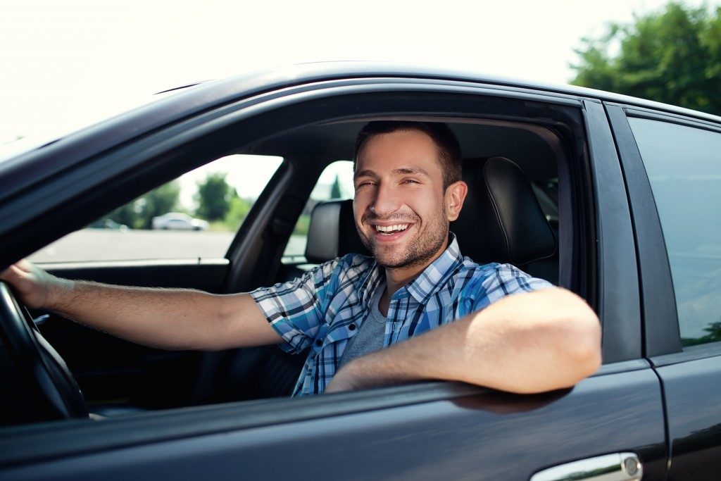 Man smiling in his car