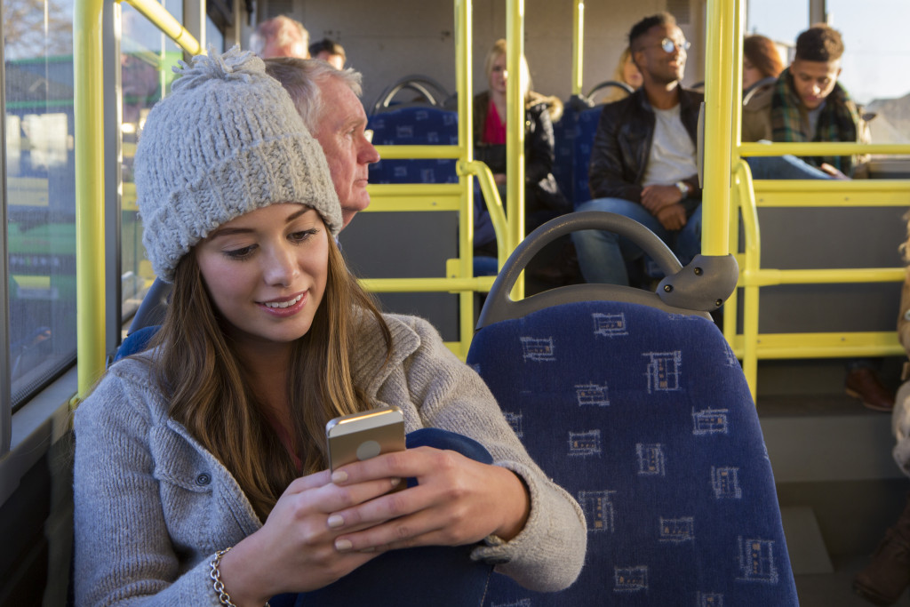 woman using her smart phone on public transportation