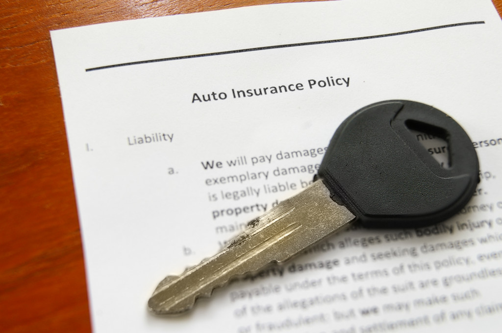 auto insurance policy document with car key on top