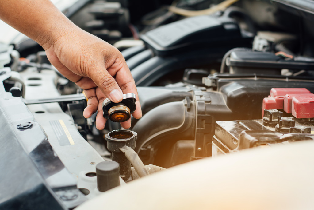 lifting a cover to check car fluid