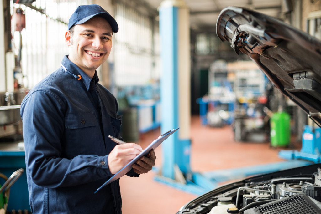 auto mechanic taking notes of car status